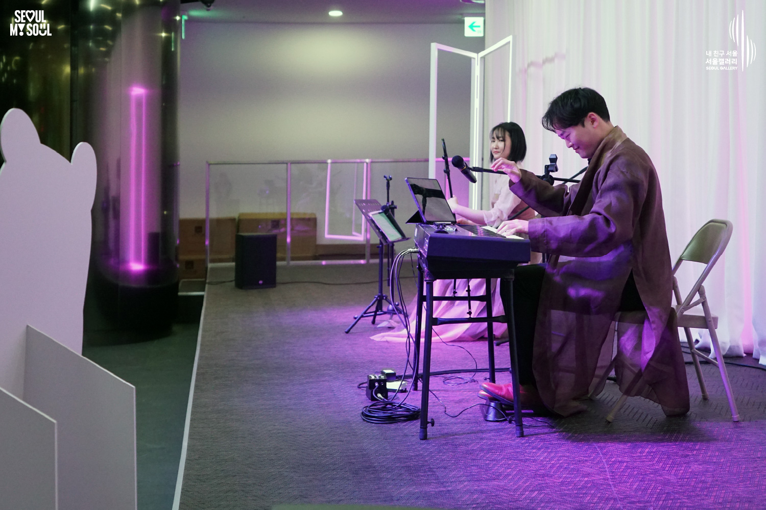 A keyboard player and haegeum player both in hanbok perform on a purple-lit stage at Seoul Gallery, with "SEOUL MY SOUL" and "Seoul Gallery" logos visible.