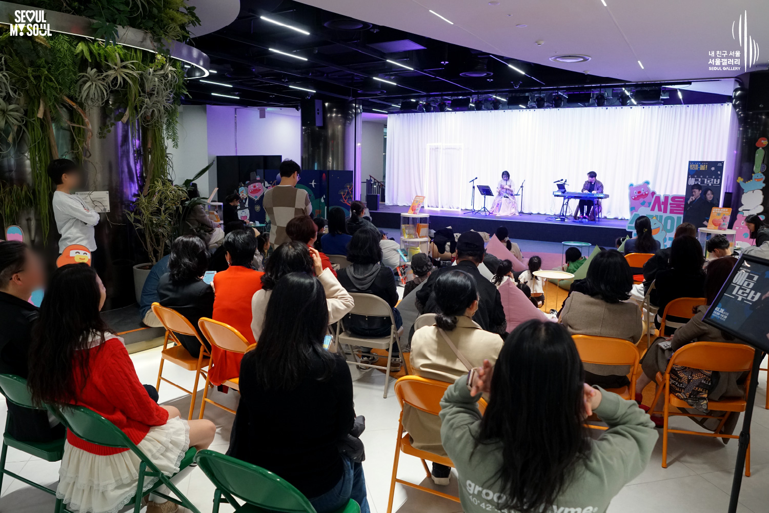 The duo Haegeum Groove performs at Seoul Gallery's Seoul Stage Lounge event before a large seated audience, with "SEOUL MY SOUL" and "Seoul Gallery" logos visible.
